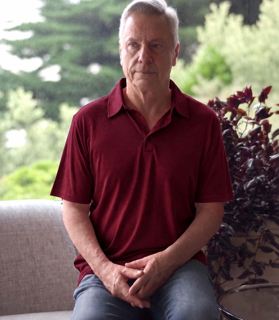 Man wearing a Silkspun Short Sleeve Polo Shirt in Bordeaux Red