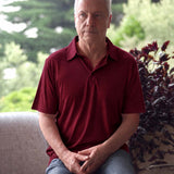 Man wearing a Silkspun Short Sleeve Polo Shirt in Bordeaux Red