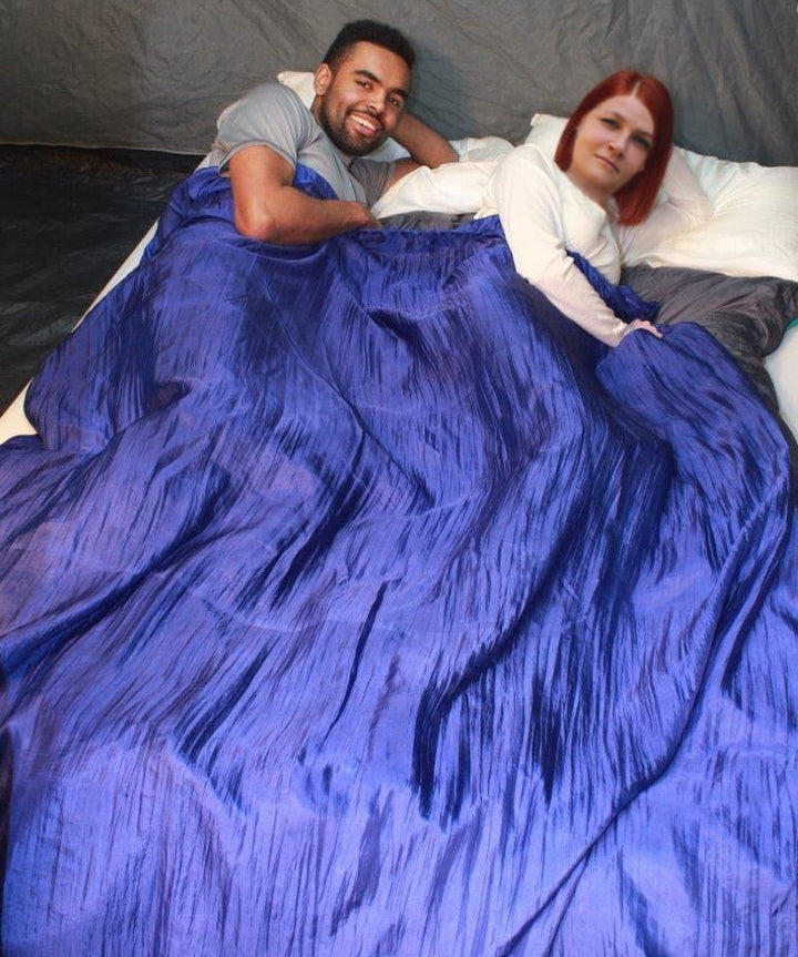 Two people sharing a 100% silk double sleeping bag liner in a tent.