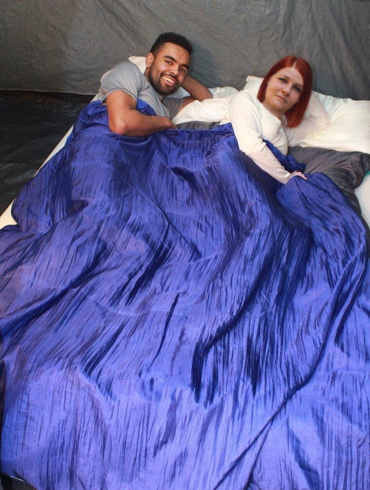 Two people sharing a 100% silk double sleeping bag liner in a tent.